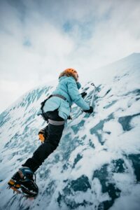 Person climbing an icy mountain with determination