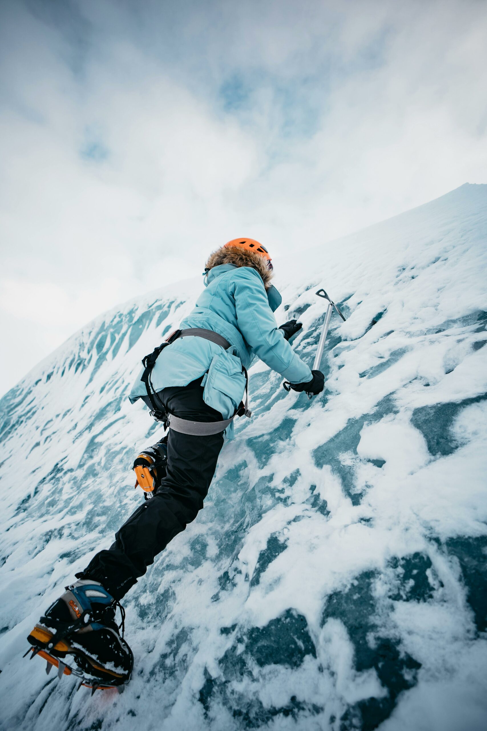 Person climbing an icy mountain with determination